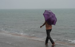 File: A man holds an umbrella during the heavy rains. Thilina Kaluthotage/NurPhoto via AFP