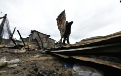 File: Community members clear the debris after a shack burned to the ground at Moeggesukkel Informal Settlement. Gallo Images/Die Burger/Lulama Zenzile