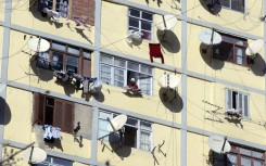 File: An apartment building full of satellite dishes on balconies. AP/Fayez Nureldine
