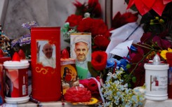 Candles and flowers are laid at the statue of John Paul II at the Gemelli University Hospital where Pope Francis is hospitalised with pneumonia. AFP/Dimitar Dilkoff
