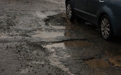 File: A vehicle driving through a pothole-ridden street. Nasir Kachroo/NurPhoto via AFP