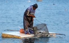 A Palestinian man stands on the door of a refrigerator that he uses as a makeshift rowing boat. AFP/Bashar Taleb