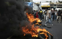 Demonstrators burn tires while blocking a street during a protest against mandatory vehicle insurance in Guatemala City. AFP/Edwin Bercian