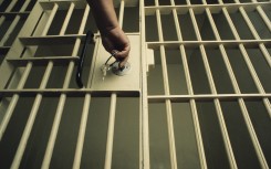An officer locking a jail cell. GettyImages/Charles O'Rear