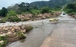 A vehicle driving through a flooded river. eNCA/Zanele Buthelezi