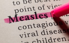 The word "measles" seen in a dictionary. GettyImages/Devonyu