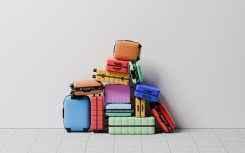 A large group of luggage stacked in a pile on top of each other. GettyImages/J Studios