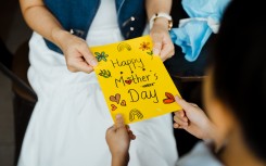 Close-up of woman receiving a Mother's Day card.GettyImages/Chong Kee Siong