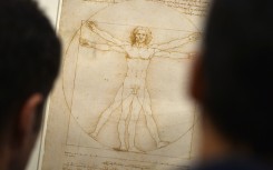 People look at the "Vitruvian Man" a drawing by Leonardo da Vinci. AFP/Gabriel Bouys