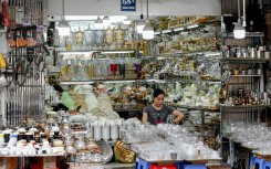 A saleswoman uses her phone as she waits for customers at a home appliance store in Hanoi. AFP/Nhac Nguyen