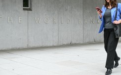 A woman walks by the World Bank headquarters in Washington. STR/NurPhoto via AFP