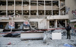 An Israeli police officer inspects the site where an Iranian ballistic missile reportedly struck in Haifa, Israel. Matan Golan/Middle East Images via AFP