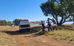 Police (SAPS) and forensic services carry a body of a flood victim to a vehicle in Mthatha - Eastern Cape floods