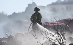  A firefighter sprays water near Perris, California. Mario Tama/Getty Images/AFP