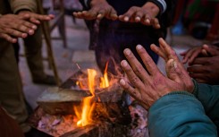 People gathered around a glowing fire on a cold winter evening. GettyImages/Uma Shankar sharma