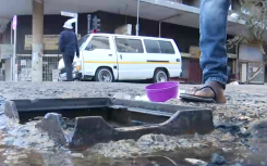 Residents using leaking manholes for water.