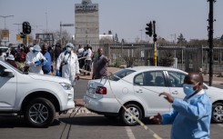 Forensic Police stands around a crime scene at the Maponya Mall in Soweto.