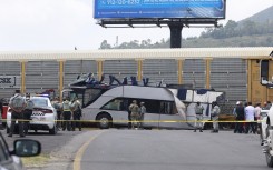 National guard members stand next to the wreckage of a passenger bus involved in an accident with a train. AFP/Ramses Vlades