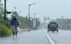 A man walks along a road amid heavy rain due to weather patterns from Super Typhoon Ragasa in Lal-lo town, Cagayan province. AFP/John Dimain