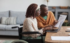 Woman in a wheelchair being assisted in a workplace