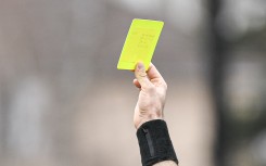 File: A referee's hand with a yellow card. Victor Joly/DPPI via AFP