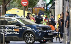 Police and emergency service workers are seen near the site of a collapsed building which was being refurbished in Madrid on October 7, 2025.
