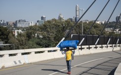 File: A man walks over a bridge connecting Alexandra to Sandton. AFP/Emmanuel Croset