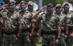 Members of the South African Police Service (SAPS) Special Task Force salute during the Integrated Law Enforcement parade near the Nasrec Expo Centre in Johannesburg, on November 19, 2025.