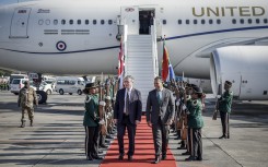 Britain's Prime Minister Keir Starmer (C-L) is welcomed by a South African representative upon his arrival at OR Tambo International Airport in Ekurhuleni on November 21, 2025 ahead of the G20 leaders' Summit.