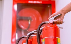 A person with fire extinguishers and a hose. GettyImages/EyeEm Mobile GmbH