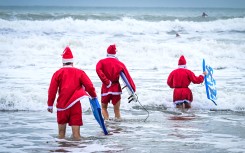 Surfers dressed as Santa Claus. AFP/Giorgio Viera