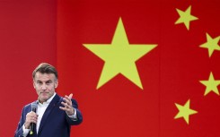 French President Emmanuel Macron speaks at Sichuan University, with China's flag in background. AFP/Pool