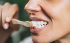A woman brushing teeth with toothpaste. Microgen Images/Science Photo Library via AFP