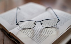 Reading glasses placed on an open book. Jean-Marc Barrère/Hans Lucas via AFP