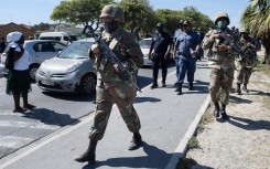South African National Defence Force (SANDF) soldiers walk with South African Police Service (SAPS) officers in Mfuleni township in Cape Town on March 31, 2026.