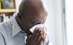 File: A man with a cold or flu blowing his nose. Frédéric Cirou/PhotoAlto via AFP
