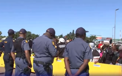 Police officers keeping an eye on demonstrators outside the Buthelezi Mall.