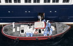 This aerial view shows health personnel assisting patients onto a boat from the cruise ship MV Hondius, while stationary off the port of Praia, the capital of Cape Verde, on May 6, 2026.