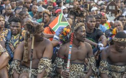 A South African flag is seen in a protester's head gear as he gathers with other protesters during a protest march against undocumented migrants in Durban on May 6, 2026.
