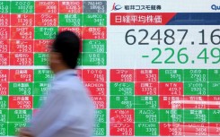 A man walks past an electronic quotation board displaying the Nikkei 225 stock prices on the Tokyo Stock Exchange. AFP/Kazuhiro Nogi