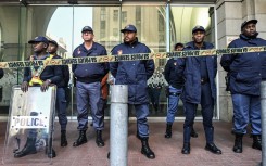 Members of the South African Police Service (SAPS) stand in formation as they monitor a demonstration by the "March and March" and Operation Dudula movements.  AFP/Rodger Bosch