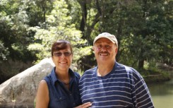 Couple standing next to each other against a park backdrop
