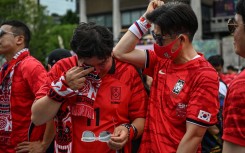 South Korean fans react after their team lost the 2026 World Cup football match against South Africa at Gwanghwamun Square in Seoul on June 25, 2026. (Photo by Jade GAO / AFP)