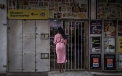 File: A resident wearing a bathrobe buys last minutes goods from a half closed shop. AFP/Marco Longari