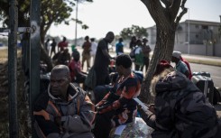Malawian undocumented migrants sit in a shaded area in Durban. AFP/Marco Longari