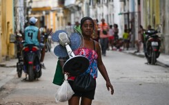 A woman carries a fan along a street in Havana during a nationwide power cut. AFP/Yamil Lage
