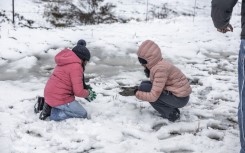 Children play with snow opposite Nottingham Road near Pietermaritzburg on 10 August. Photo by RAJESH JANTILAL / AFP