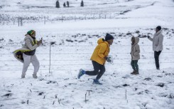 A family gathers to play in snow on Nottingham Road near Pietermaritzburg on 10 August. Photo by RAJESH JANTILAL / AFP