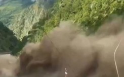 This frame grab from a UGC footage courtesy of Nepal Police shows floodwaters sweeping through houses along the Bhote Koshi River after flash floods in Rasuwa district on August 26, 2026.  Photo by-UGC / NEPAL POLICE / AFP