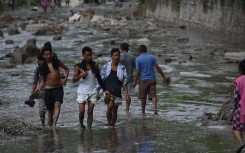 People walk along a road covered by floodwaters in Nuwakot, Nepal, on 26 August. Sunil Pradhan/Anadolu via Getty Images